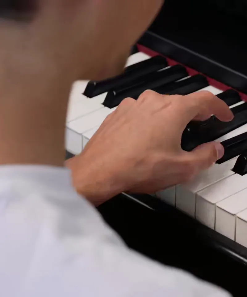 Pianist speelt met beide handen op een digitale piano